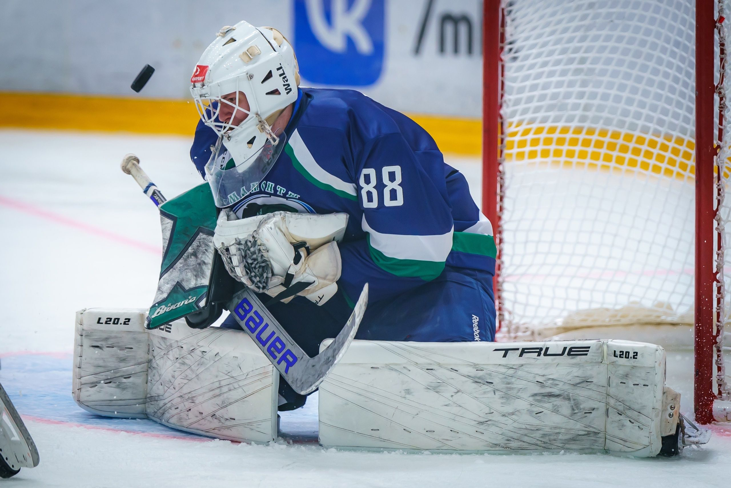 Yevgeni Volokhin making a glove save in net during a VHL game