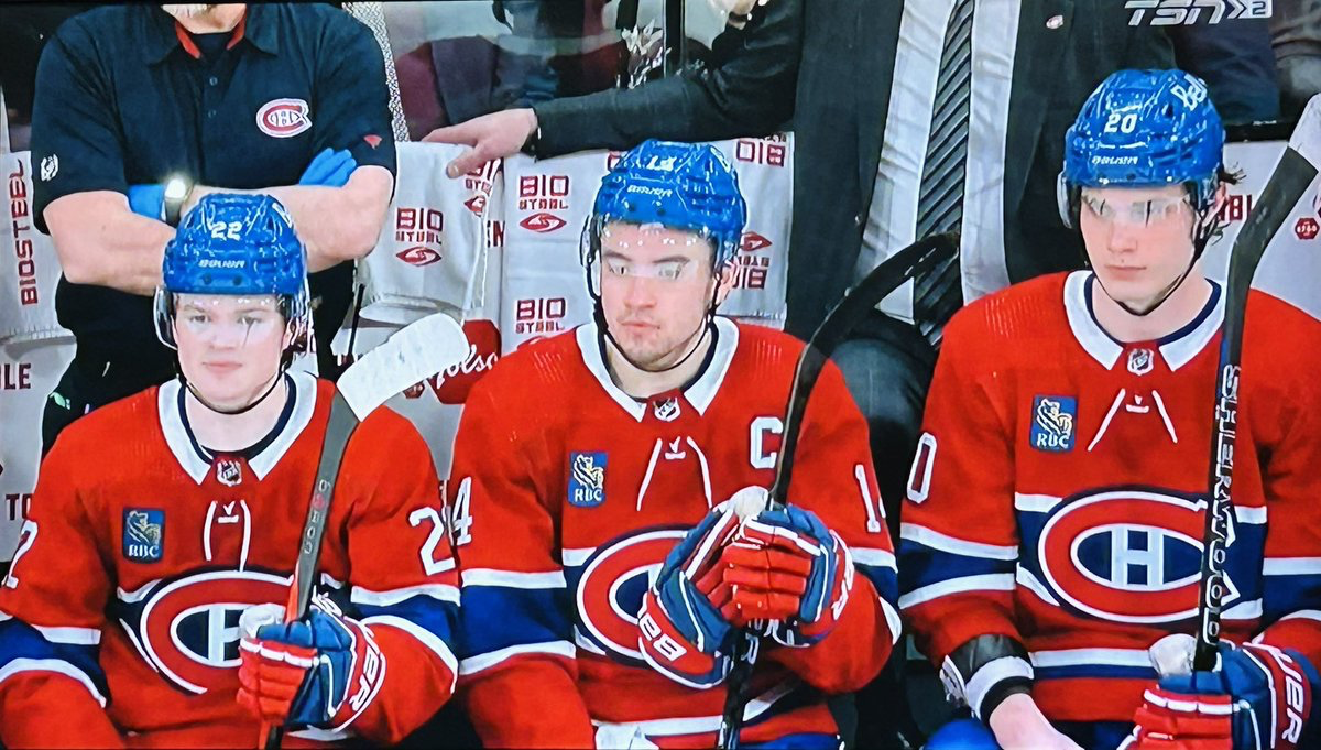 Cole Caufield, Nick Suzuki and Juraj Slafkovský of the Montreal Canadiens sitting together on the bench